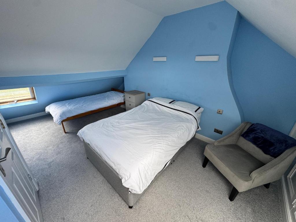 a small bedroom with two beds and a chair at Top of Family Occupied House Double Room with Free Parking in York in York