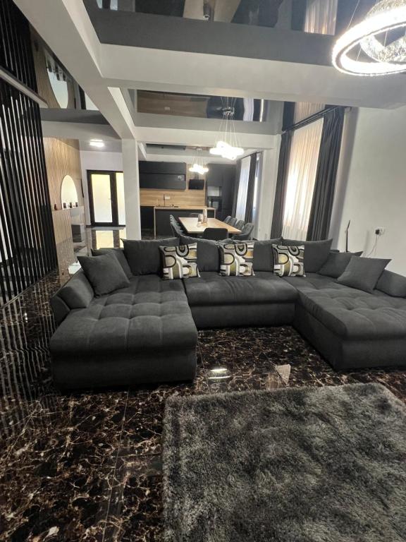 a living room with a large couch and a table at IUNIk in Azuga