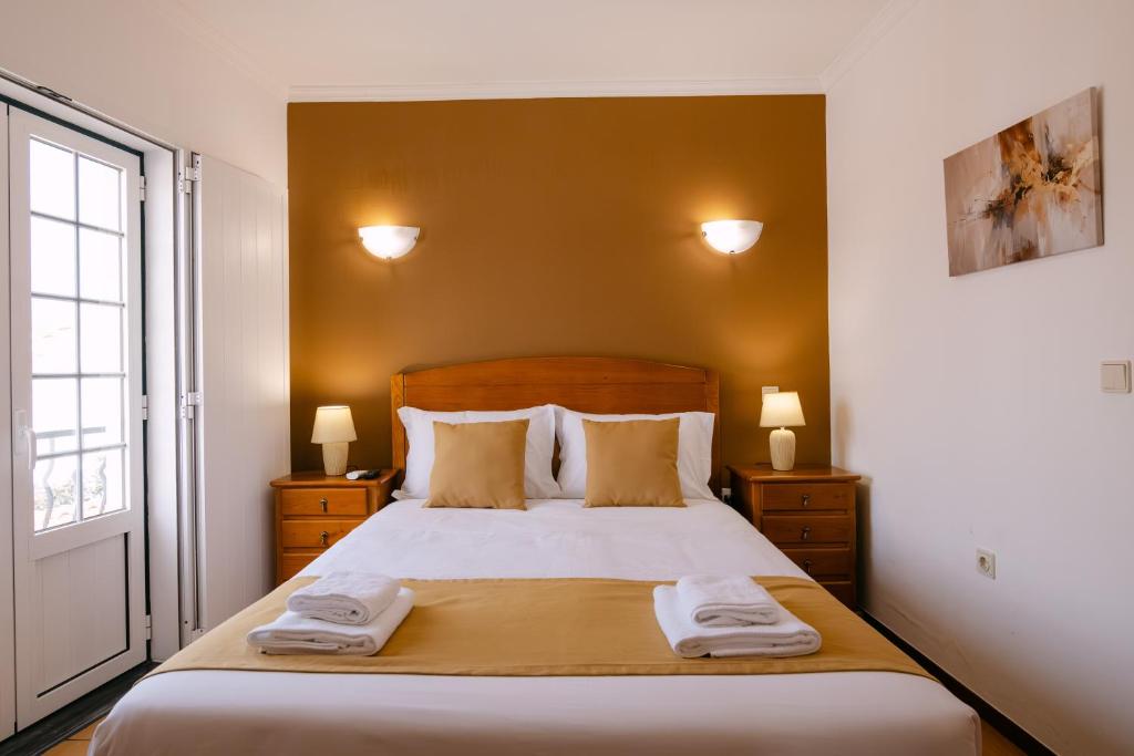a bedroom with a bed with two towels on it at Hospedaria Canto do Rossio in Vidigueira