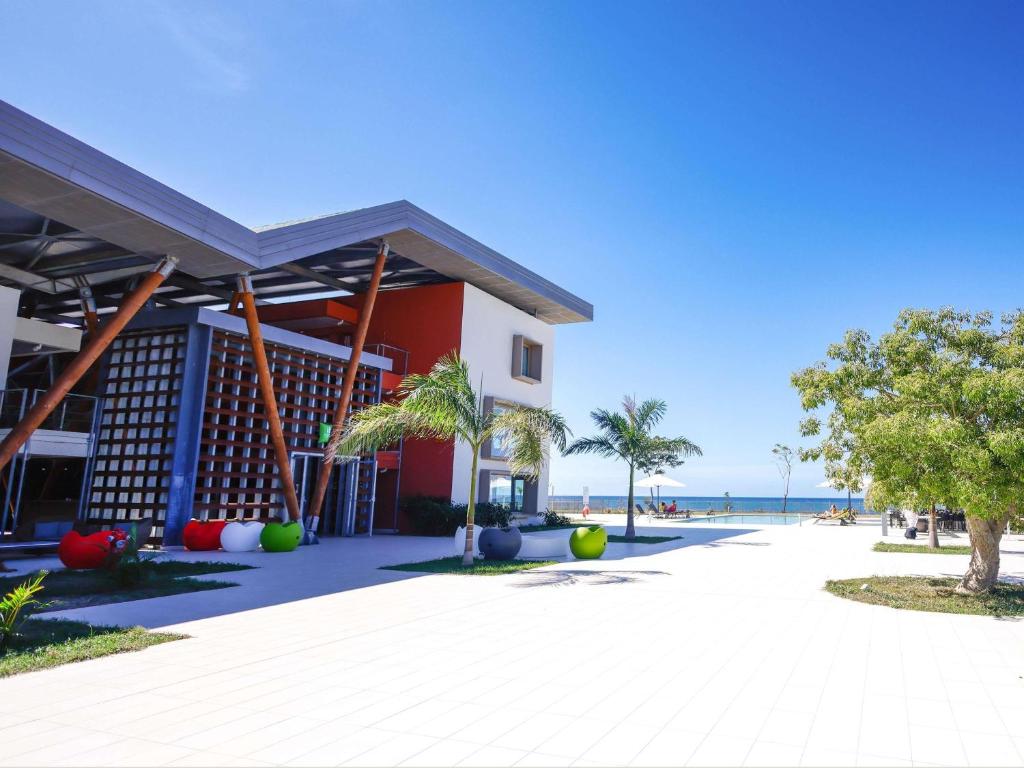 a building with the beach in the background at Ibis Styles Mayotte Aéroport in Pamandzi