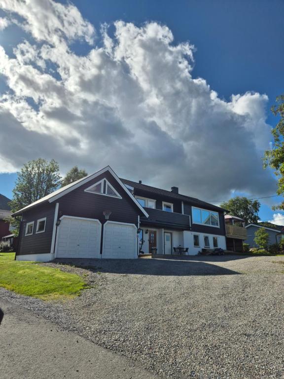 a black and white house with a garage at Cozy Home in Stokmarknes