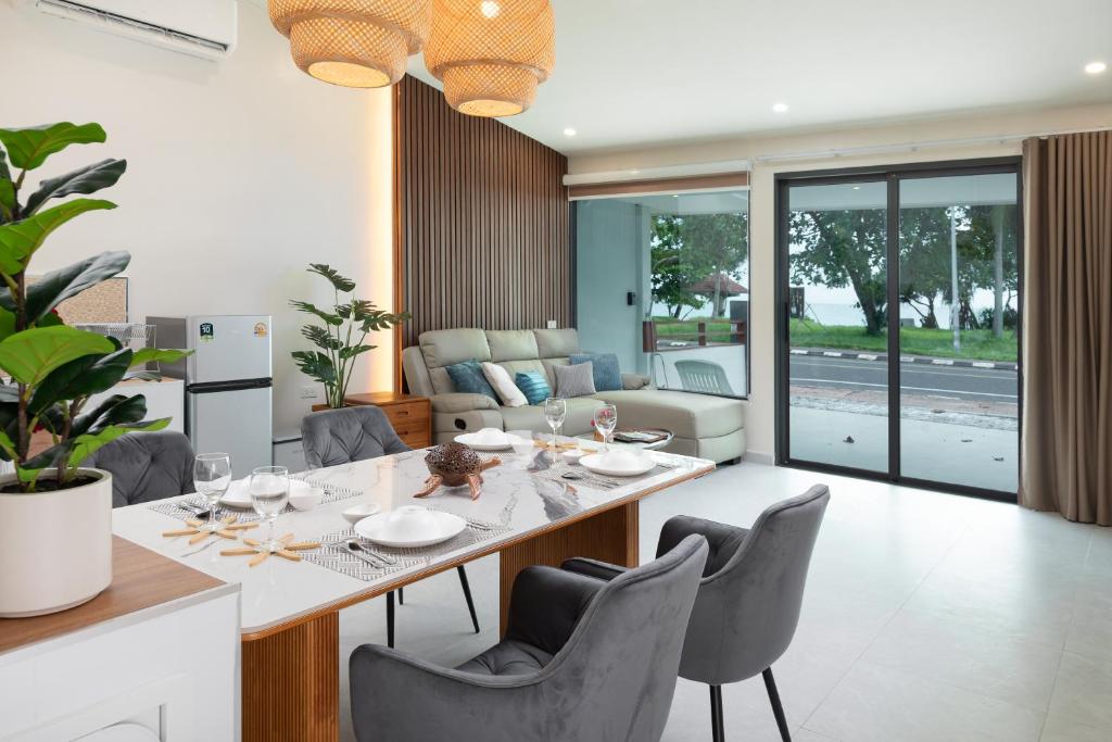a dining room and living room with a table and chairs at Turtle Tales-Tao Khon in Thai Muang