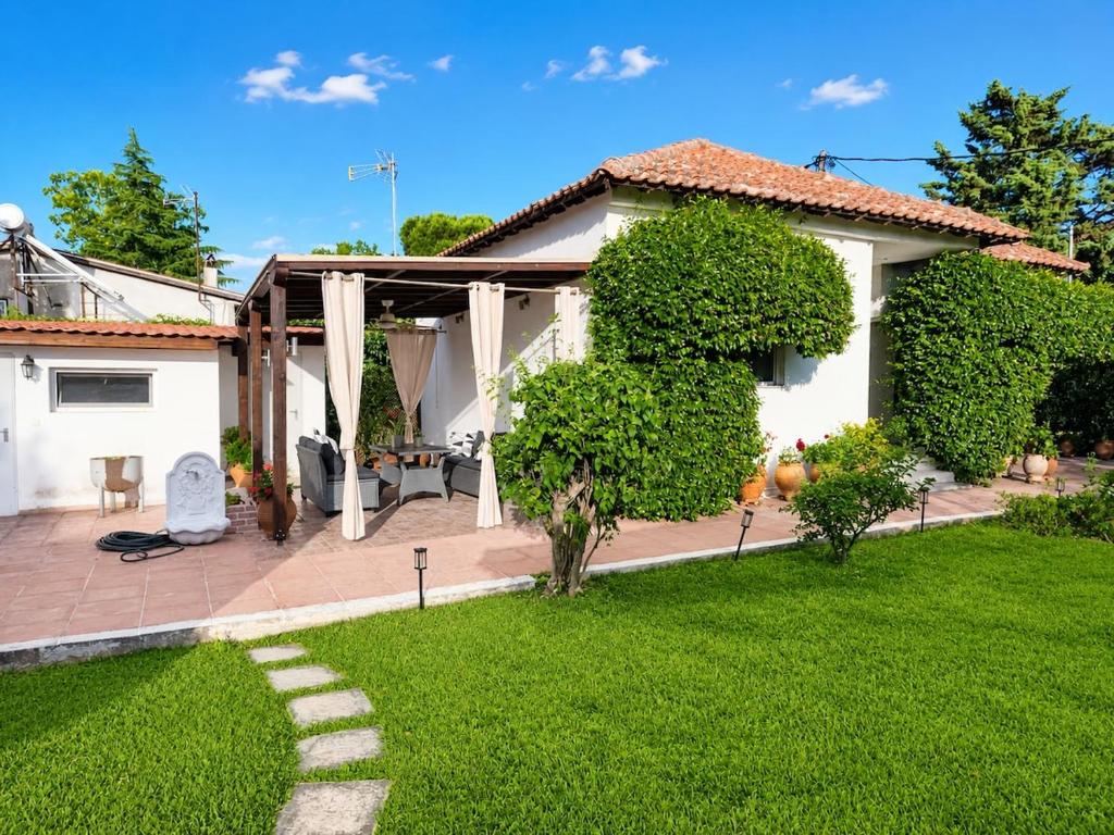 a house with a green yard with a pathway at The Secret Garden Peraia in Perea