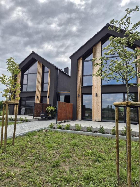 a house with a black facade with a tree at Apartamenty RIO Oława in Oława