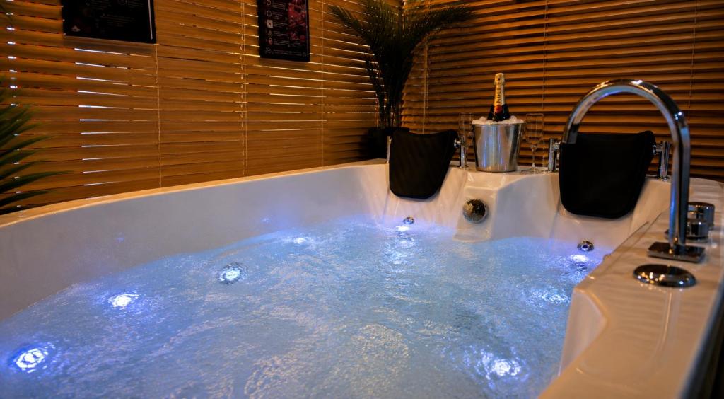 a jacuzzi tub with a faucet in a bathroom at Maison LOVEROOM 70m2 L'entre Nous in Grenoble