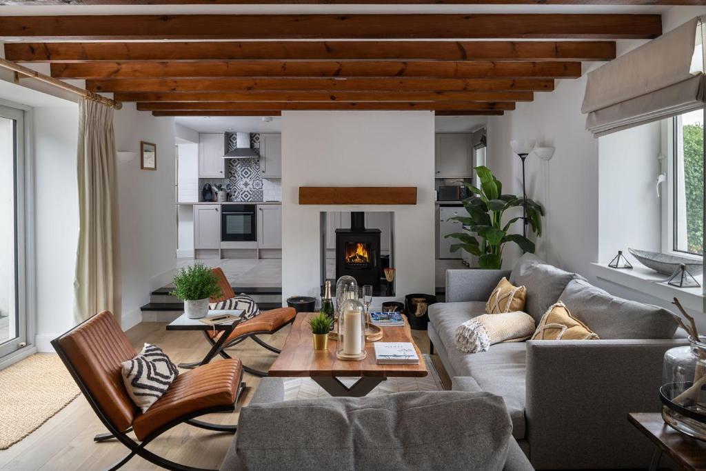 a living room with a couch and a fireplace at Bayholme House in Oxwich