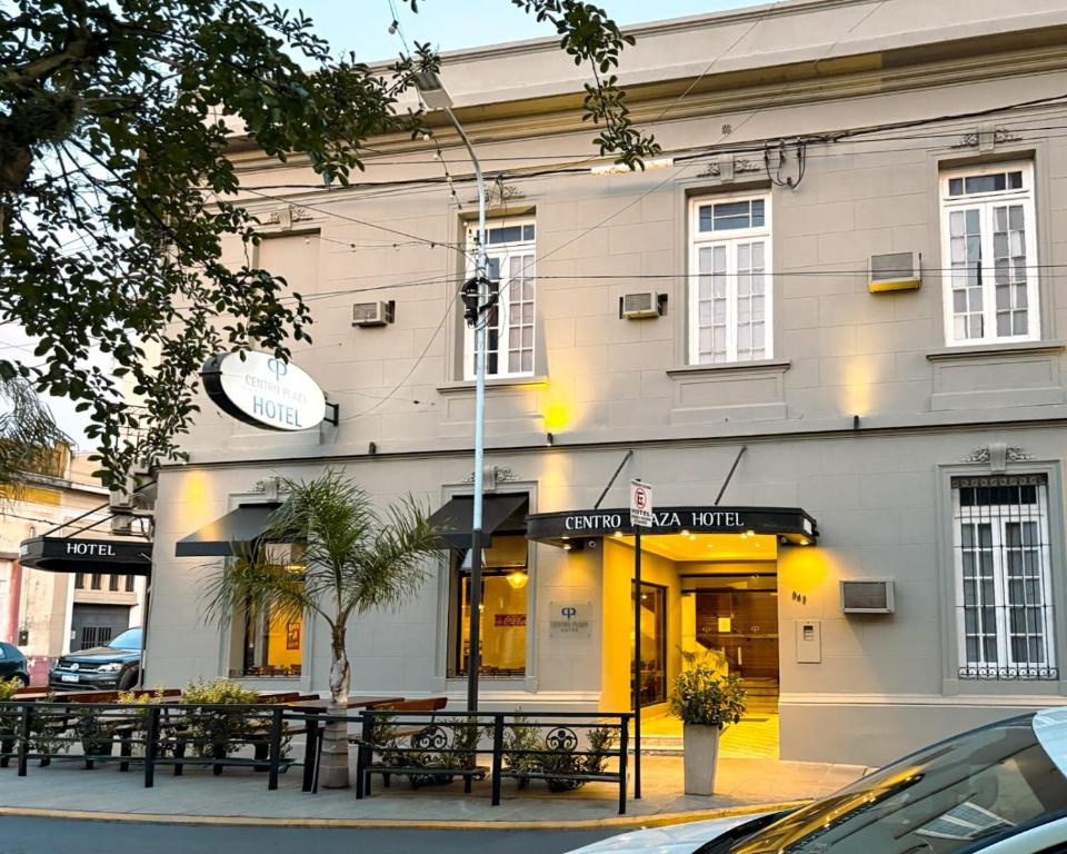 a building with tables and benches in front of it at Centro Plaza Hotel in Concordia