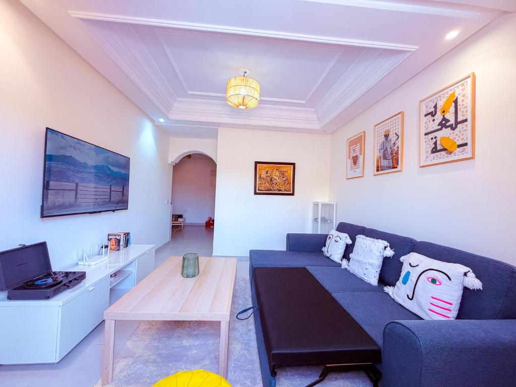 a living room with a blue couch and a table at Jardin Yves Chic 2 bedrooms - AC - Parking in Marrakesh