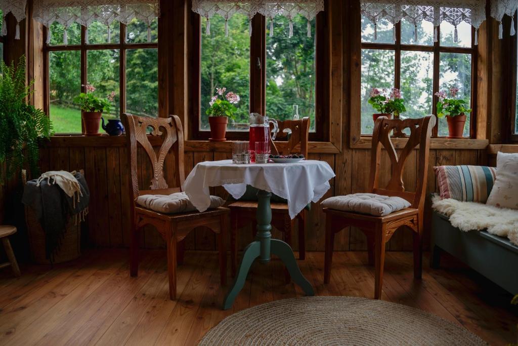 a table and chairs in a room with windows at Dom Na Biegunach in Cięcina