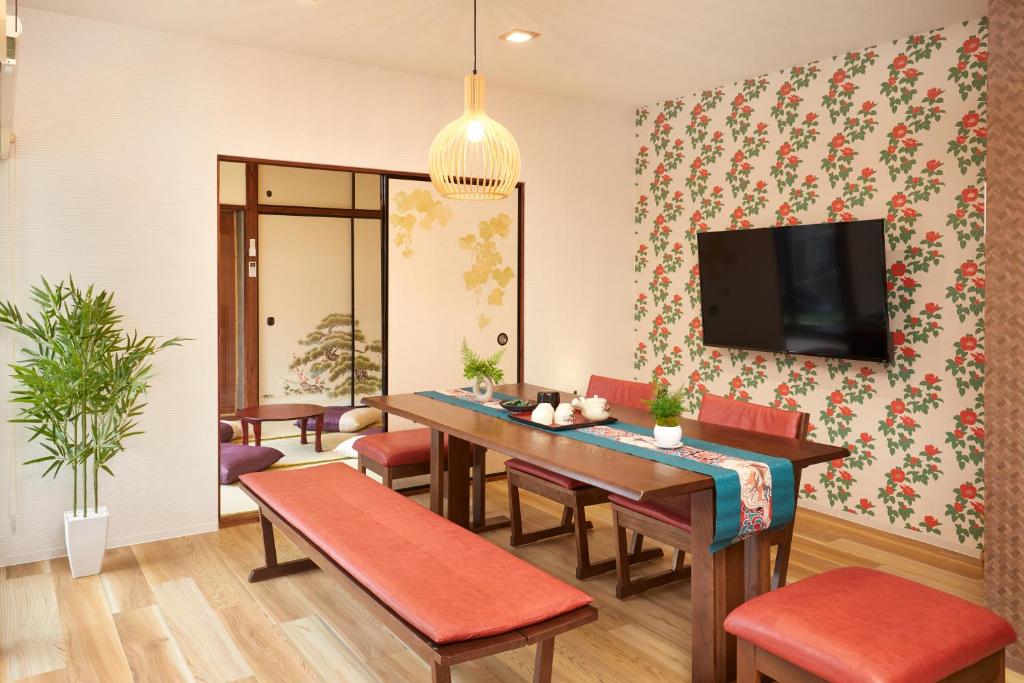 a dining room with a table and chairs and a tv at Nara Top Sights 5 to 20 Min Walk in Nara