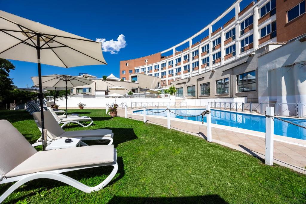 a hotel with chairs and an umbrella next to a pool at Hotel Roma Aurelia Antica in Rome