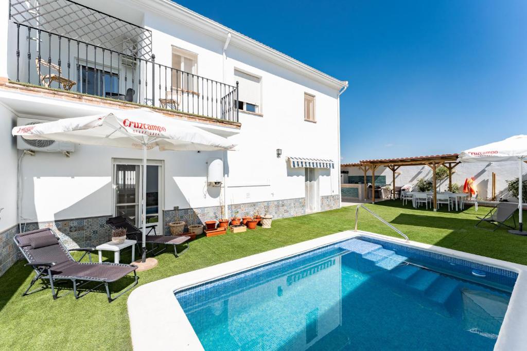 a villa with a swimming pool and a yard at MalagaSuite Villa Flor de Piedra in Fuente de Piedra