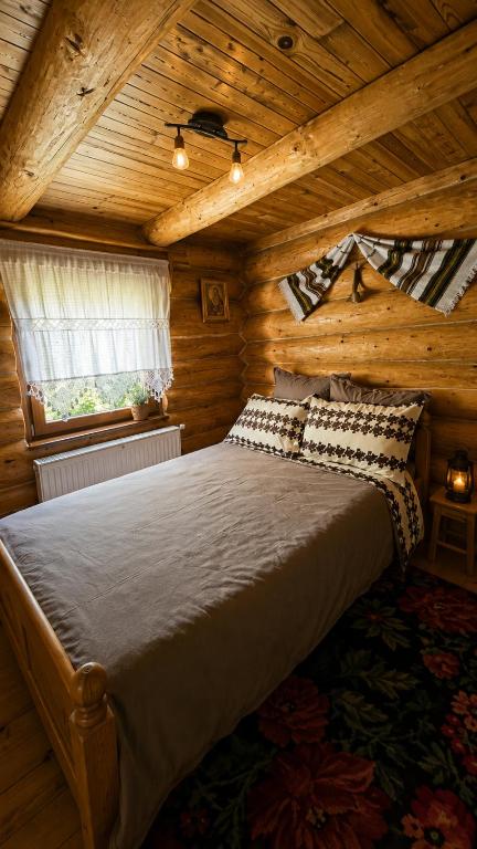 a bedroom with a bed in a wooden cabin at Cabana Perla Muncelului in Stulpicani