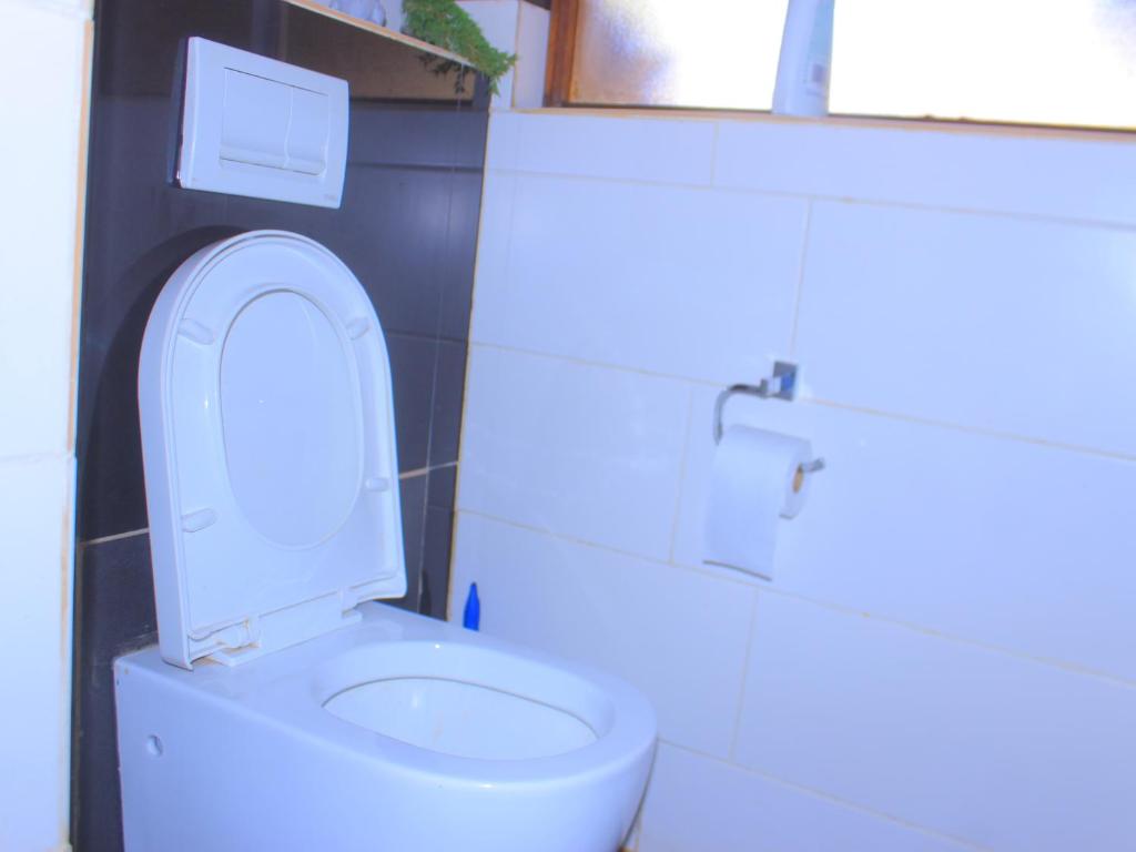 a white toilet with the lid up in a bathroom at Kat Guest house in Northam