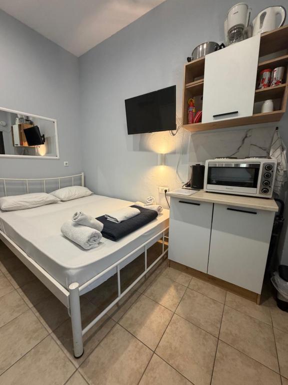 a small room with a bed with a microwave on it at Athanias Studio in Drama