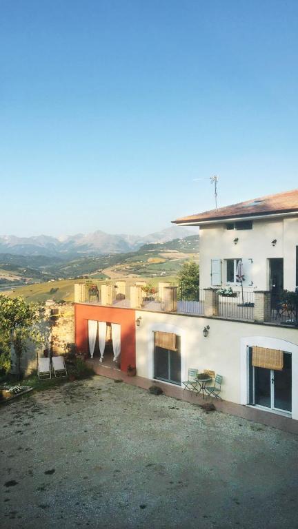 a white house with a balcony with chairs on it at Èlpari Bed&Breakfast in Montelparo
