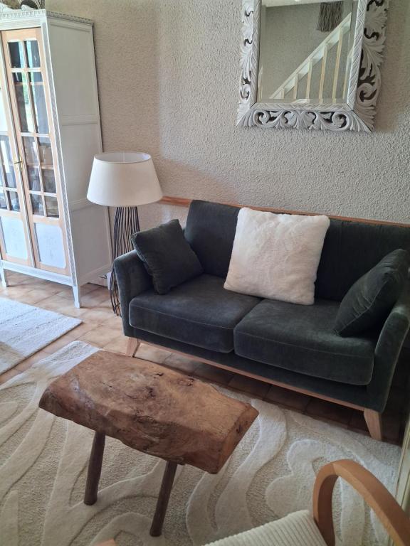 a living room with a green couch and a table at Hameau des Granges in Bourisp