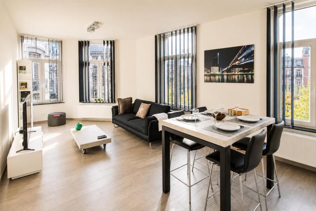 a living room with a table and a couch at Les Suites de Nanesse in Liège