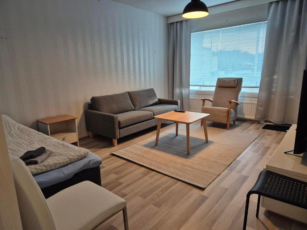 a living room with a couch and a table at Annalassa kahden makuuhuoneen asunto in Tampere