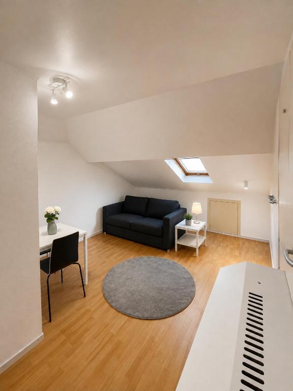 a living room with a couch and a table at Simple studio near Kirchberg in Luxembourg
