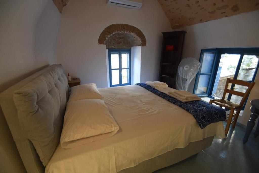 a bedroom with a large bed with a window at Avgonima Joy Medvial Suite in Chios