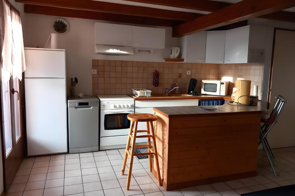 a kitchen with a white refrigerator and a counter at Gîte de montagne in Ventron