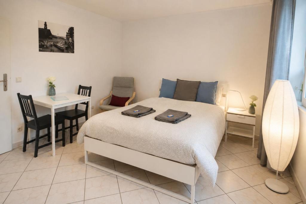 a bedroom with a bed and a table and a desk at Kirchberg Comfort Rooms in Luxembourg