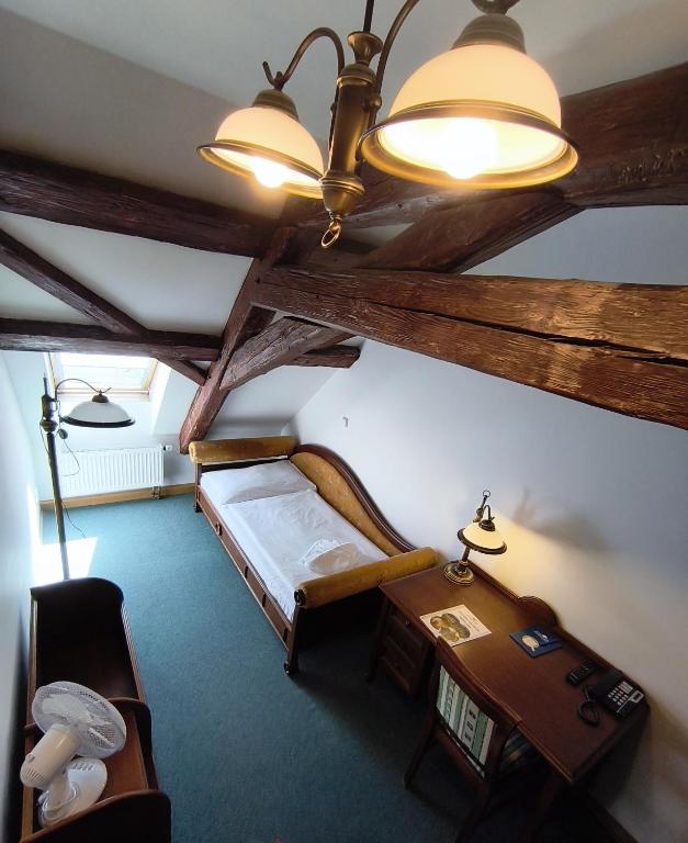 a room with a bed and a table and a ceiling at Depandance Vodoléčba in Lázně Libverda