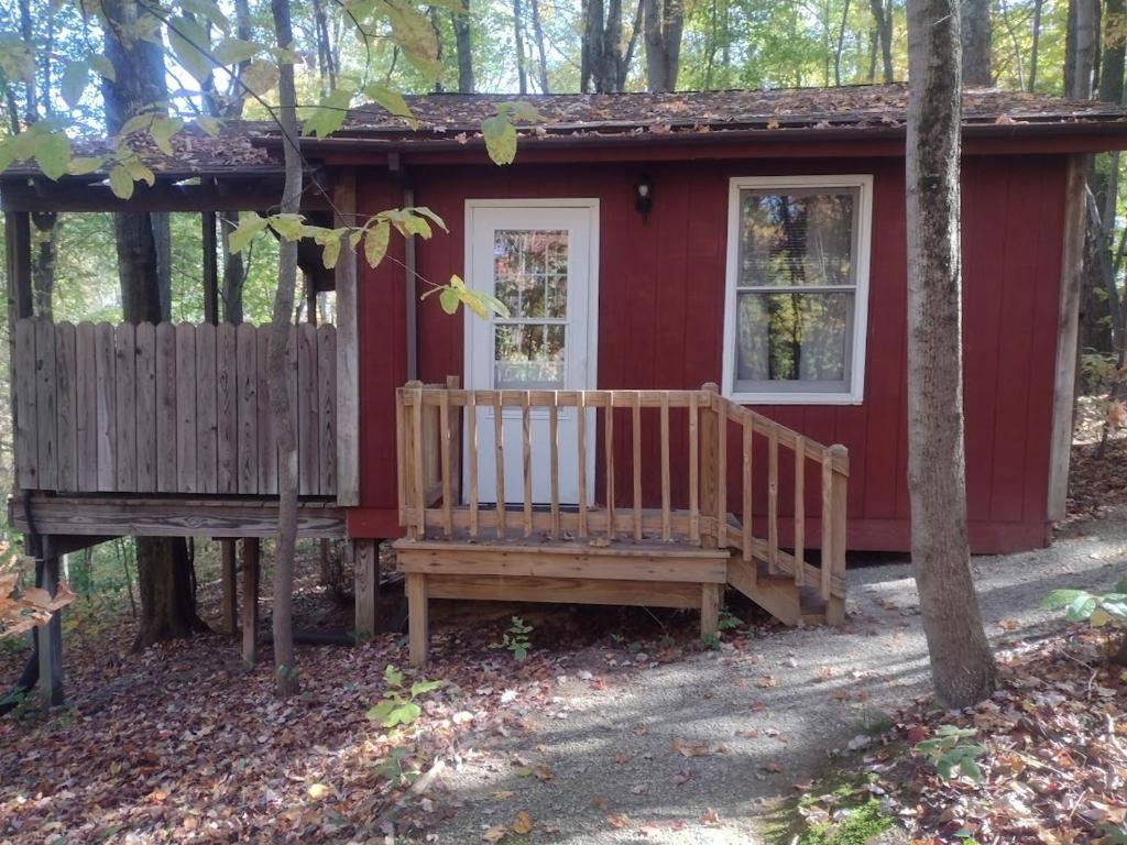 a red house with a bench in front of it at Thunder Ridge Cabins B&B - Otter Lodge in Rockbridge