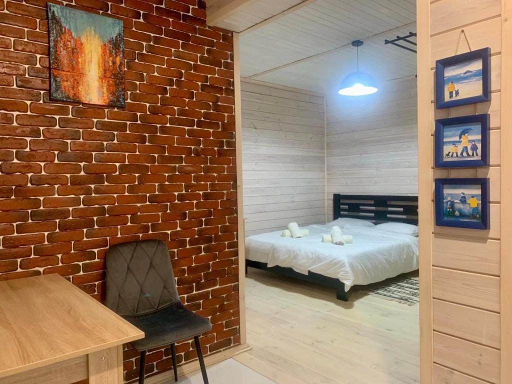 a bedroom with a bed and a brick wall at Еко апартаменти DOM Art in Ovruch