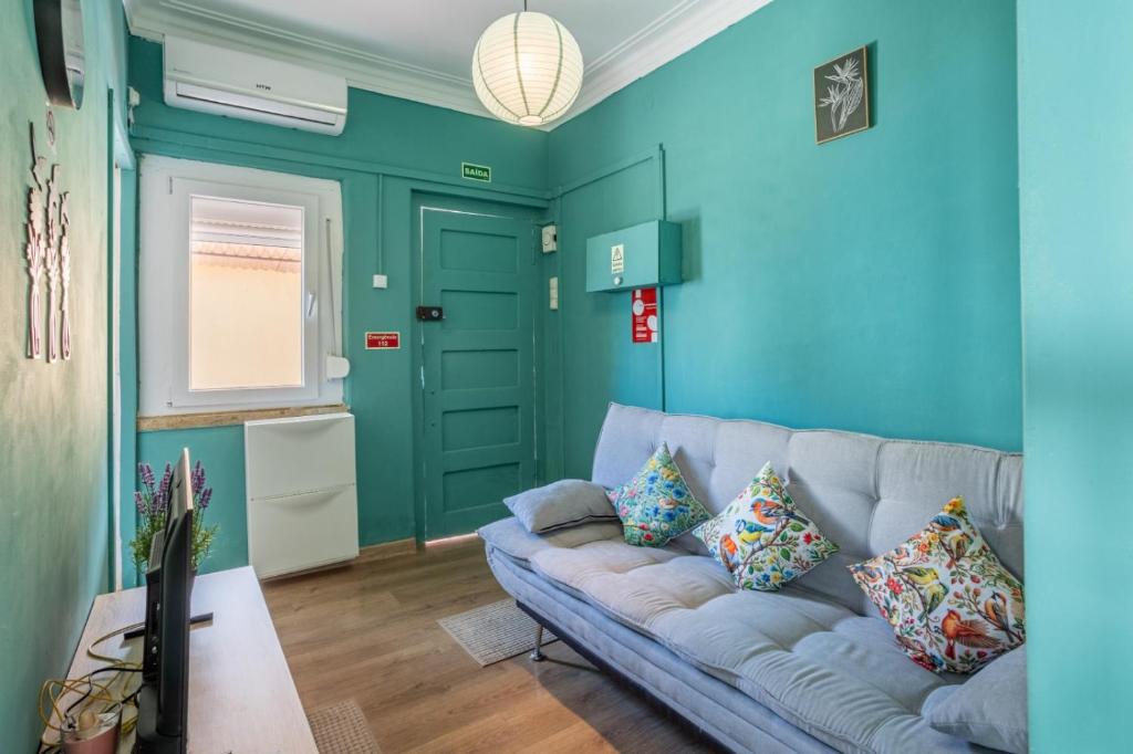 a living room with blue walls and a couch at AL Fancy Discoveries in Lisbon