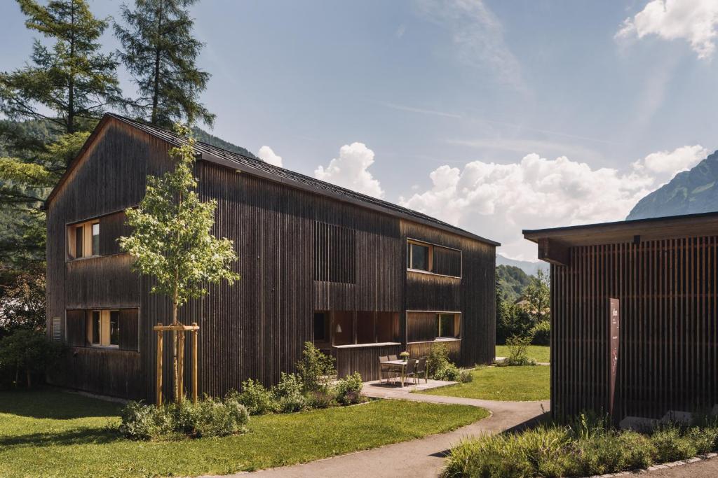 a wooden house with a tree in front of it at Ferienhaus Islen in Mellau
