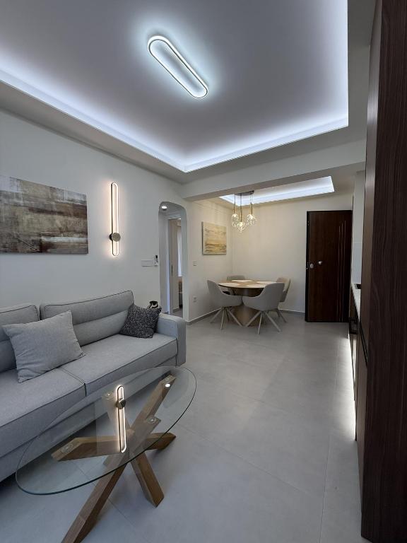 a living room with a couch and a table at Loutraki Sea Breeze Sunset Apt in Loutraki
