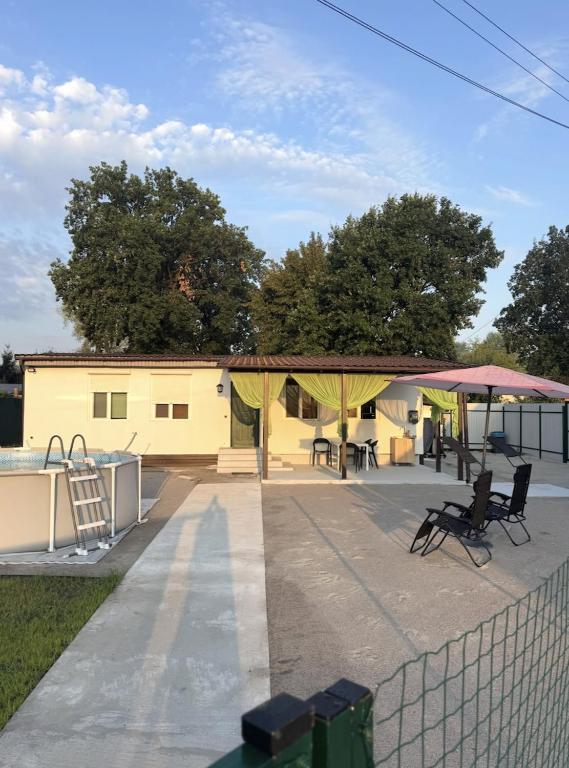 a patio with a tent and chairs and a fence at Будинок на Дніпрі in Kozin
