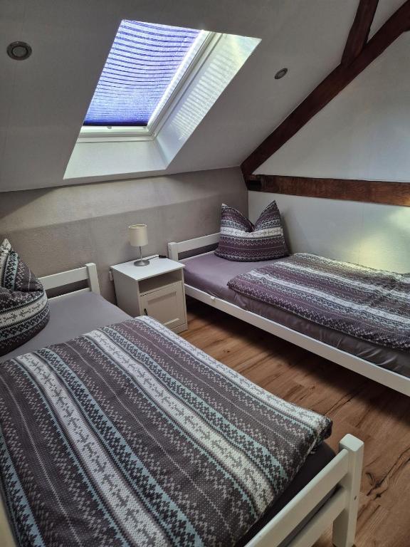 a attic bedroom with two beds and a skylight at Ferienwohnung Moos in Haiger