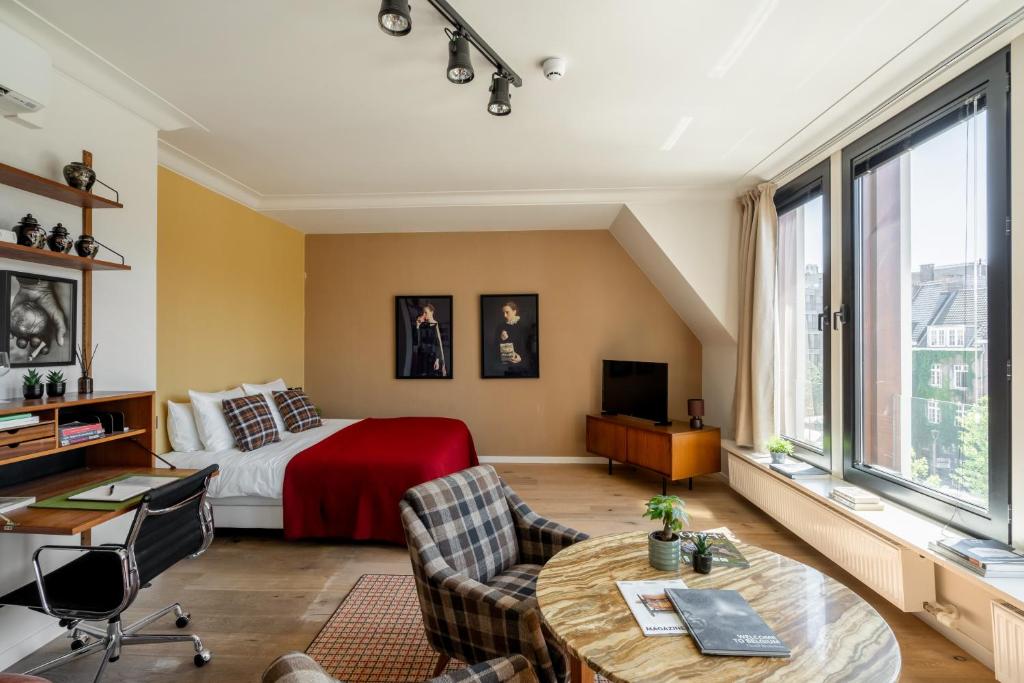 a bedroom with a bed and a table and chairs at A Place Antwerp - Boutique Suites & Flats - Vrijdagmarkt 1 in Antwerp
