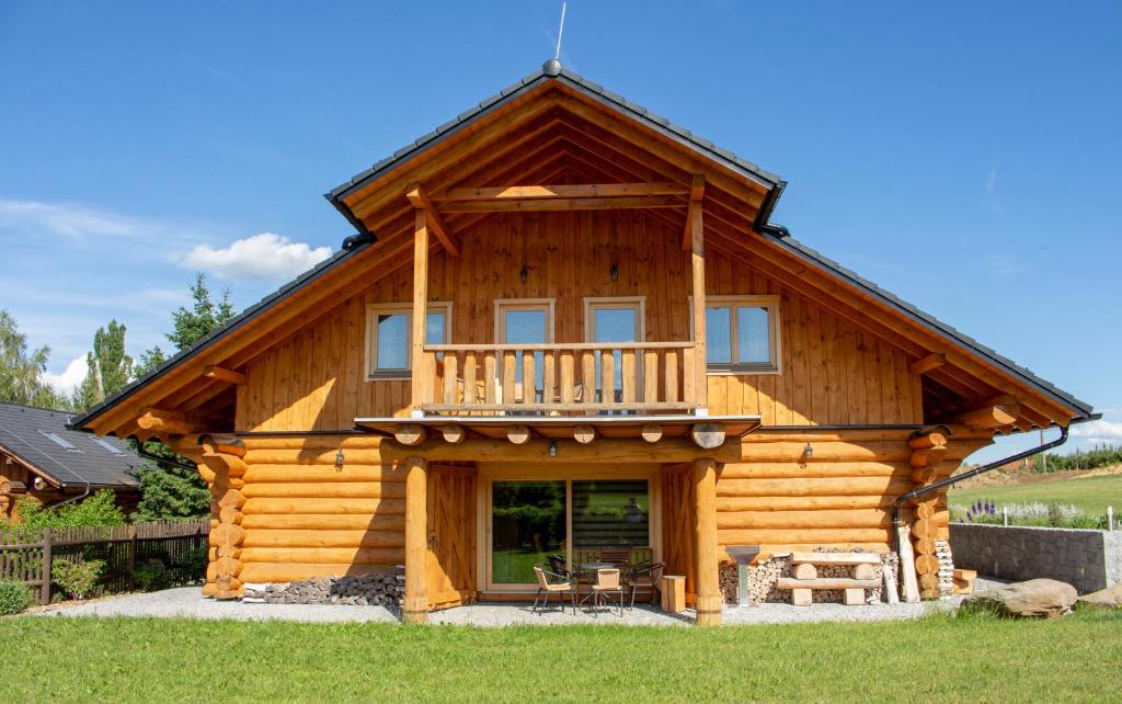 a log cabin with a porch and a balcony at Usedlost u rybníka in Velký Bor