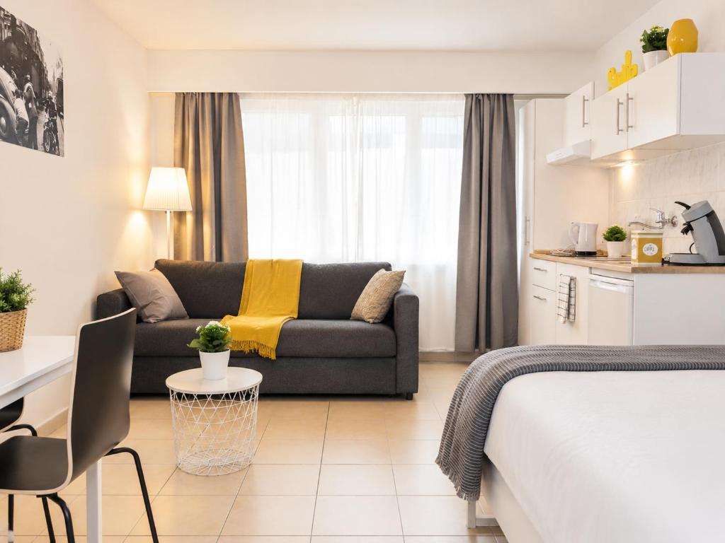 a room with a bed and a couch and a kitchen at nice central studio in Luxembourg