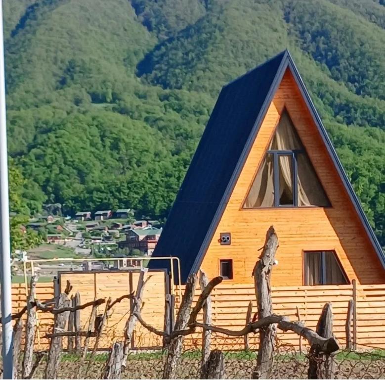 a barn with a blue roof and a fence at Green zone Aframe in Qusar