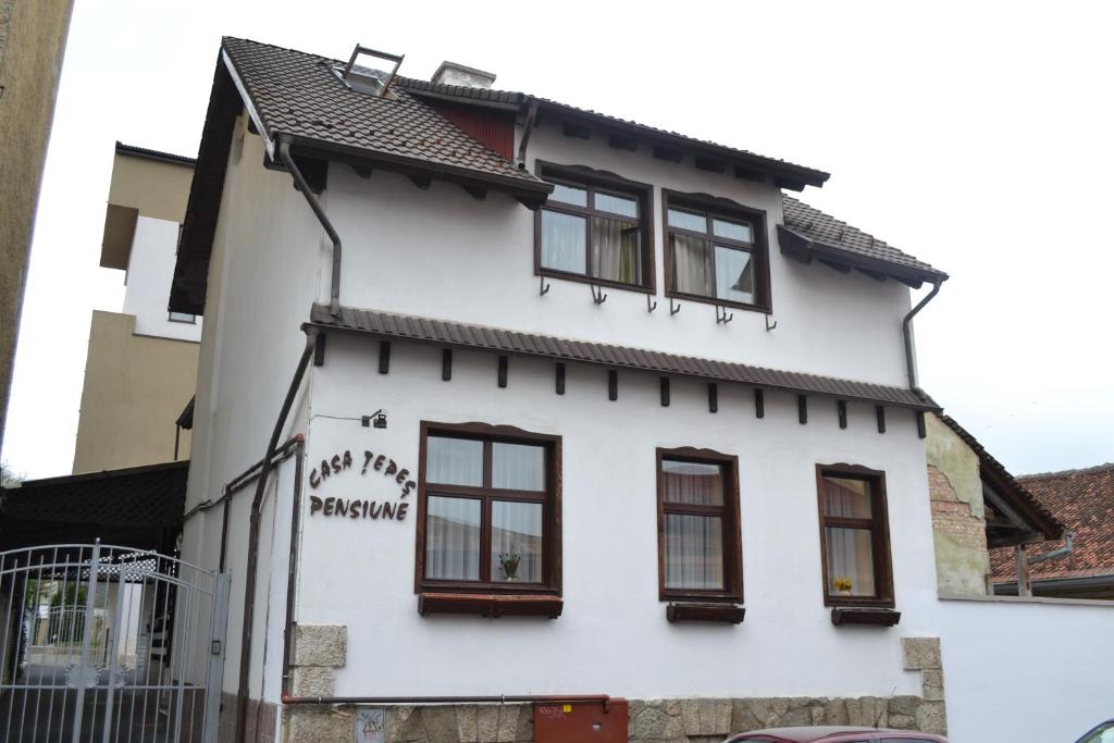una casa blanca con ventanas y graffiti en ella en Pensiunea Casa Tepes, en Brasov