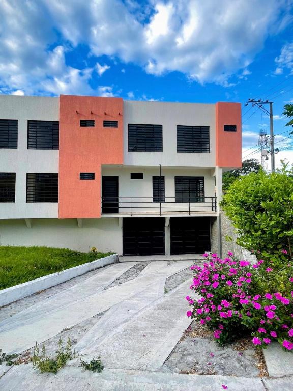 a building with pink flowers in front of it at Apartamentos El Remanso in Mariquita