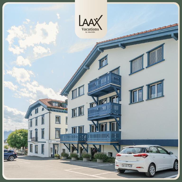 a white building with a car parked in front of it at Freestyle Alpine Design-Studios - Pool, Parking & Balcony in Center Laax by BlueHills Vacations in Laax