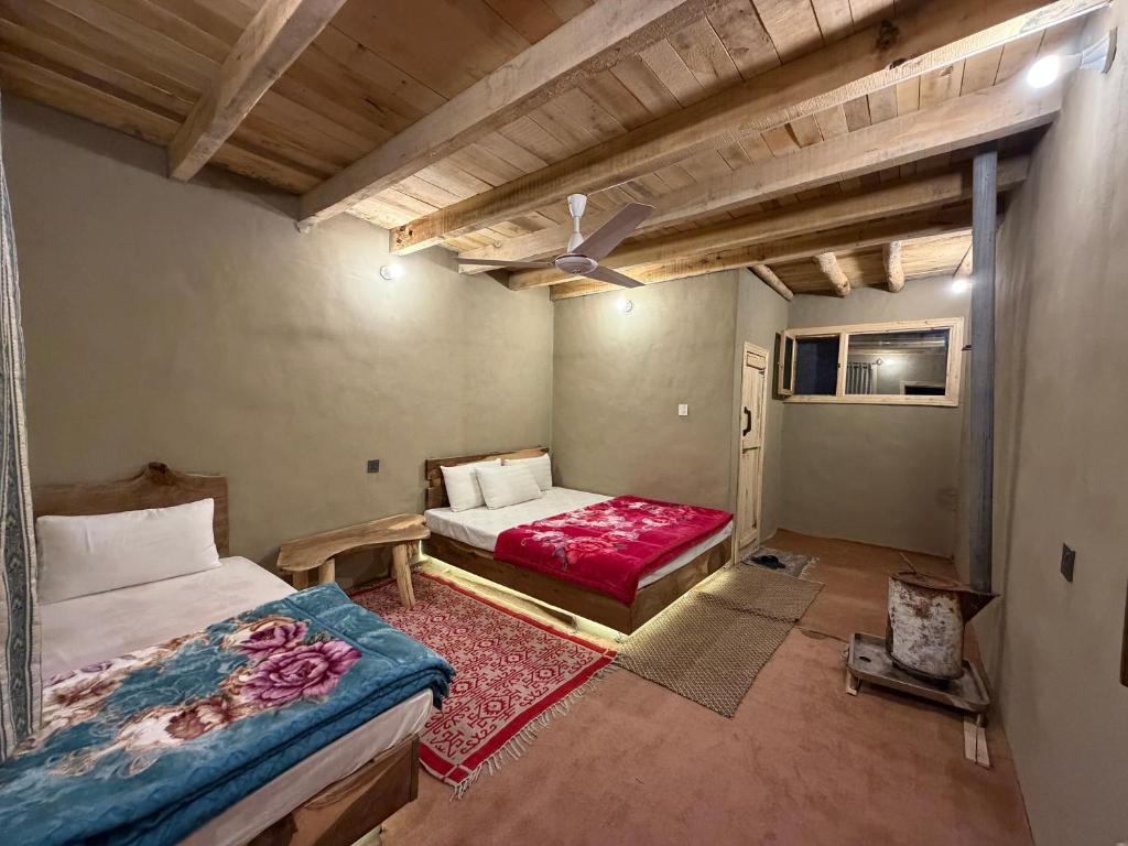 a bedroom with two beds and a ceiling fan at MUD ROOMS by MANOKUR- E- BASA in Minapin