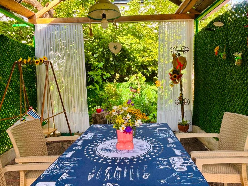 a table with a blue table cloth and flowers on a patio at Getaway Nook in Dedoplis Tskaro