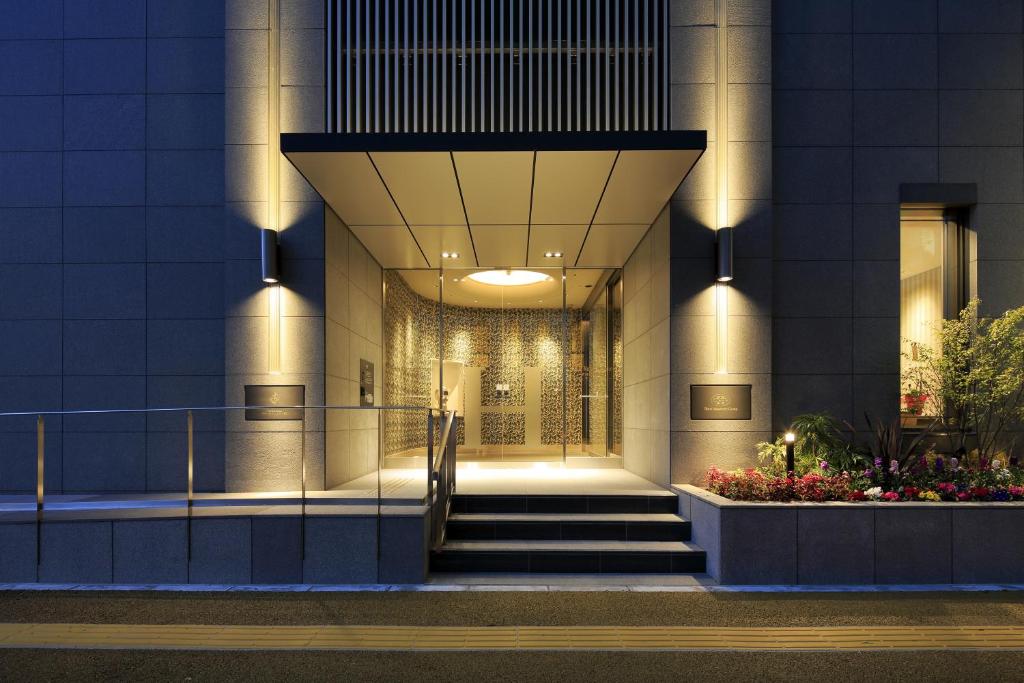 a lobby of a building with stairs and flowers at Hotel Monte Hermana Fukuoka in Fukuoka