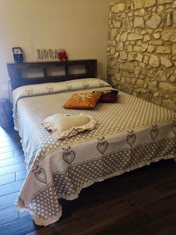 a bed in a room with a stone wall at Il Richiamo della Cascata in Papigno