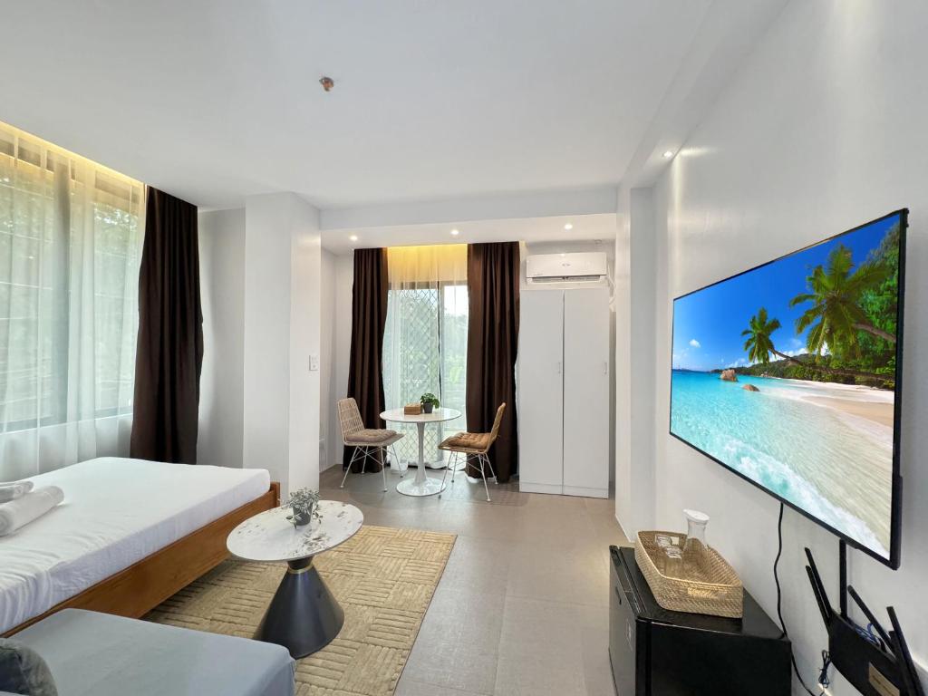 a hotel room with a large tv on the wall at El Jardin Residences in Panglao Island