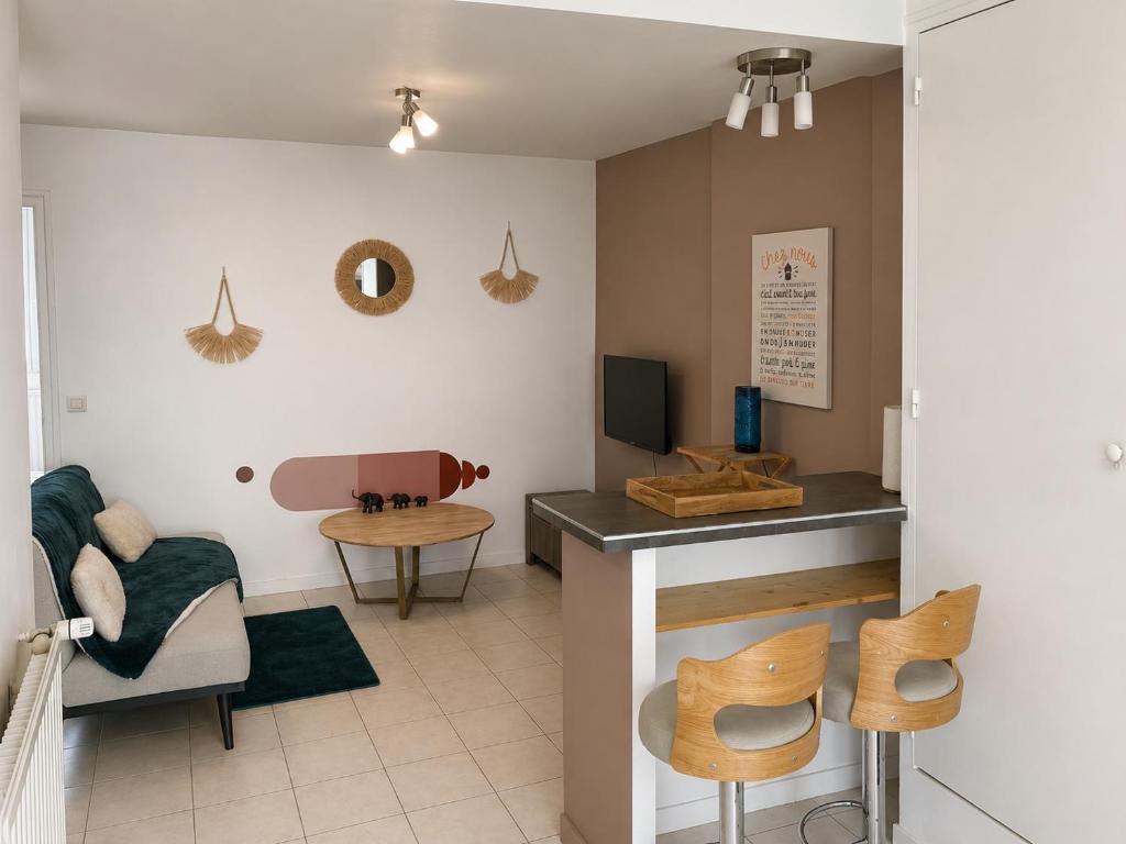 a living room with a table and chairs at l 'Escapade Atlantique in Saint-Nazaire
