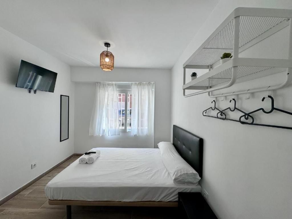 a white bedroom with a bed and a window at Next Stop Atocha in Madrid