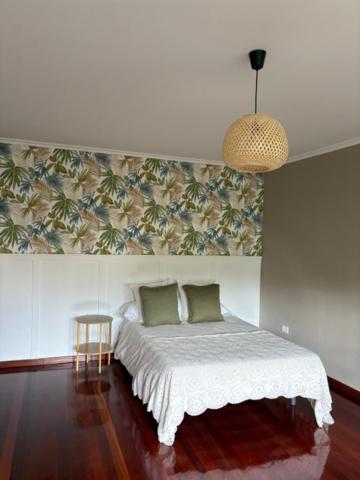 a bedroom with a bed and a pendant light at Lar de Luz in Palas de Rei